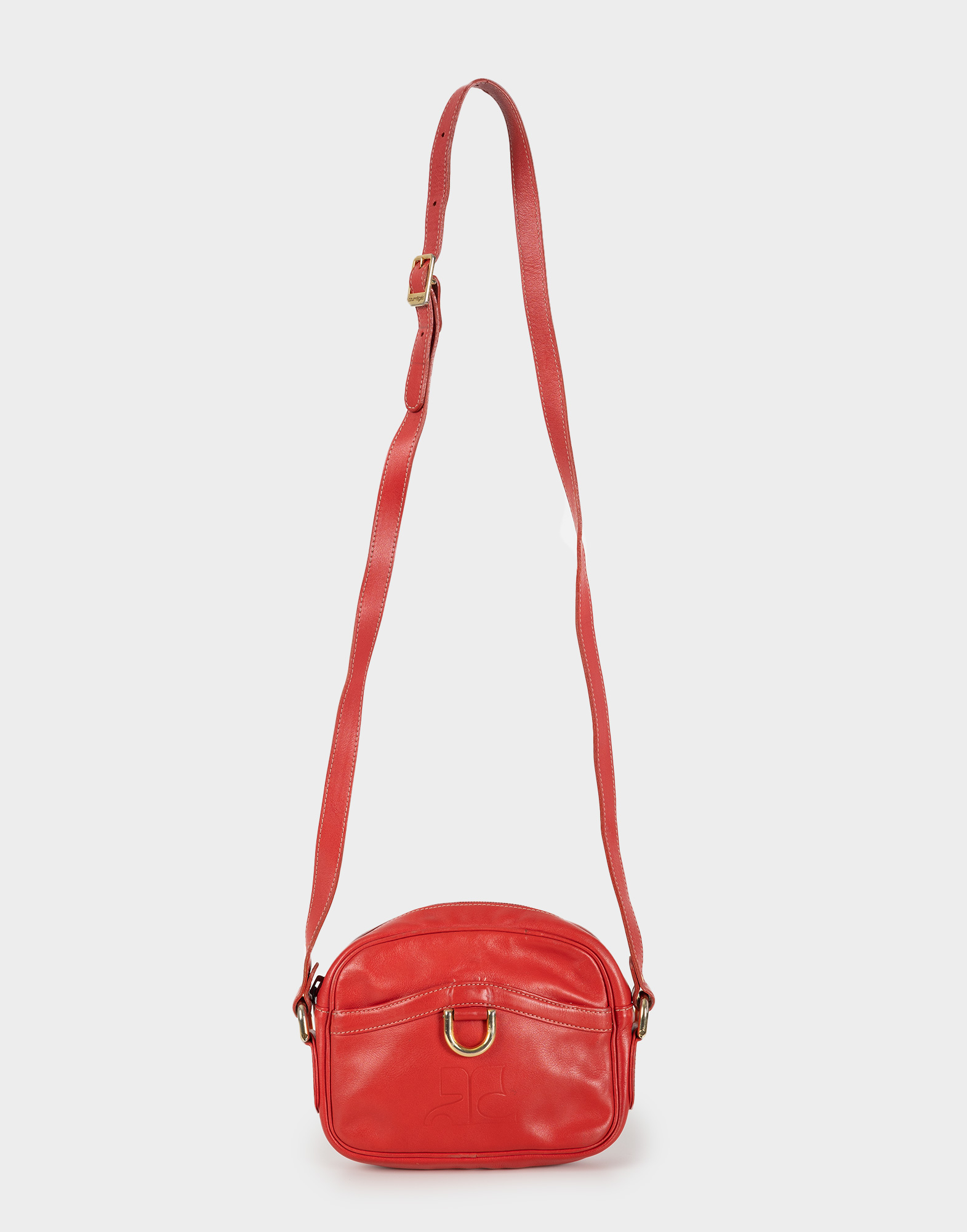 borsa rossa piccola da donna in pelle con tracolla regolabile fotografata su sfondo grigio