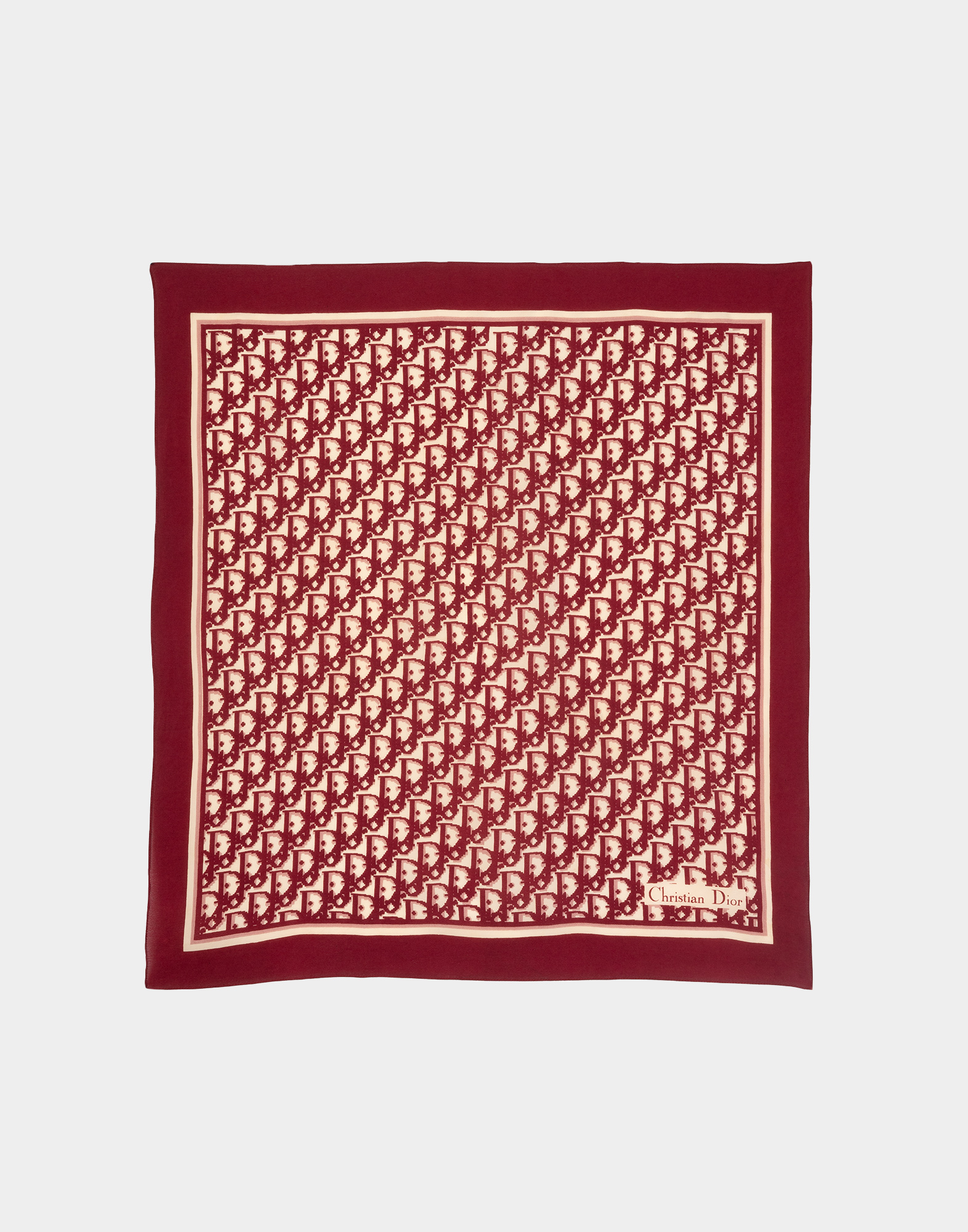 Red monogram scarf, photographed on a gray background.