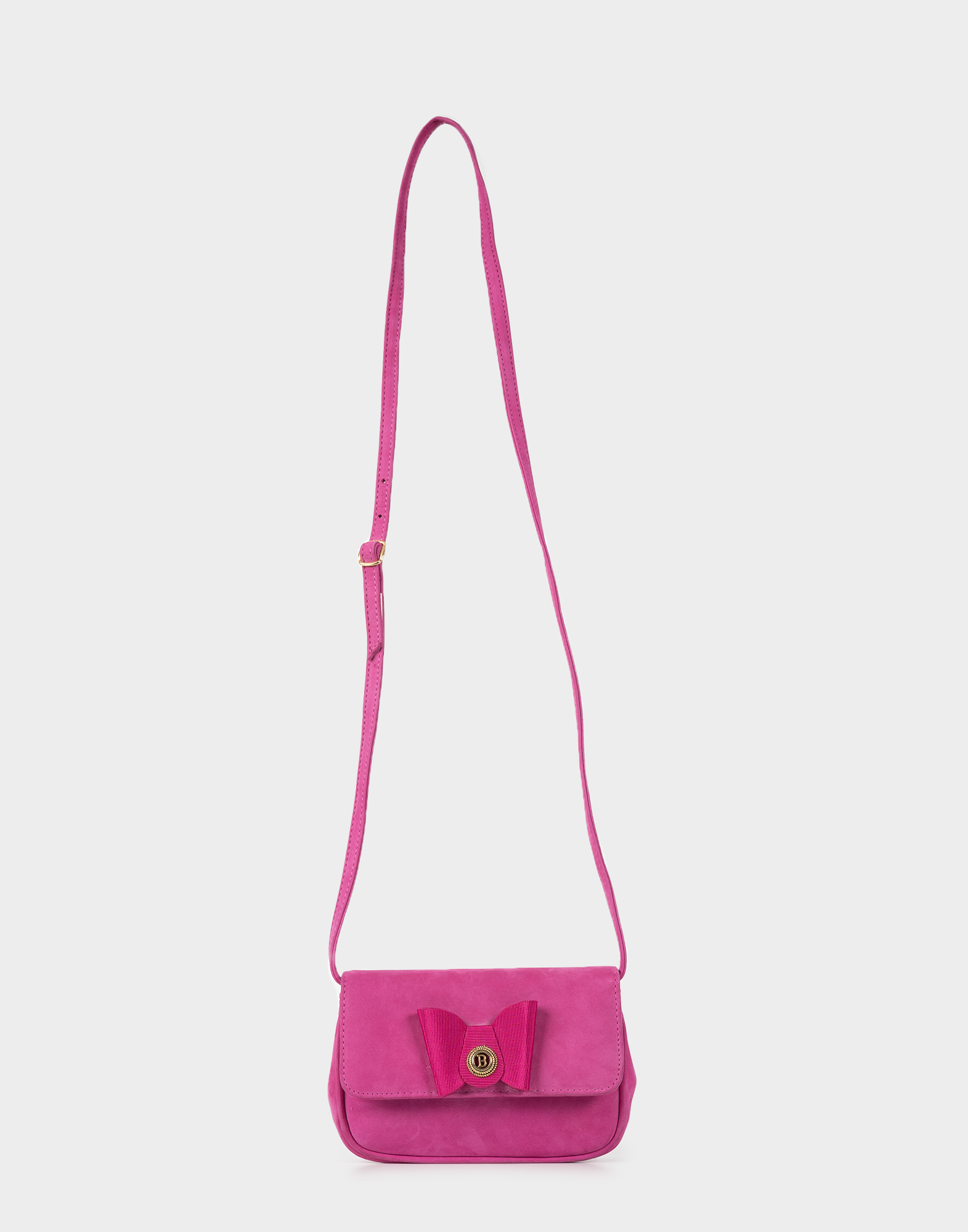 Small pink suede-like fabric bag with a long adjustable shoulder strap, flap closure, and a satin bow on the front.