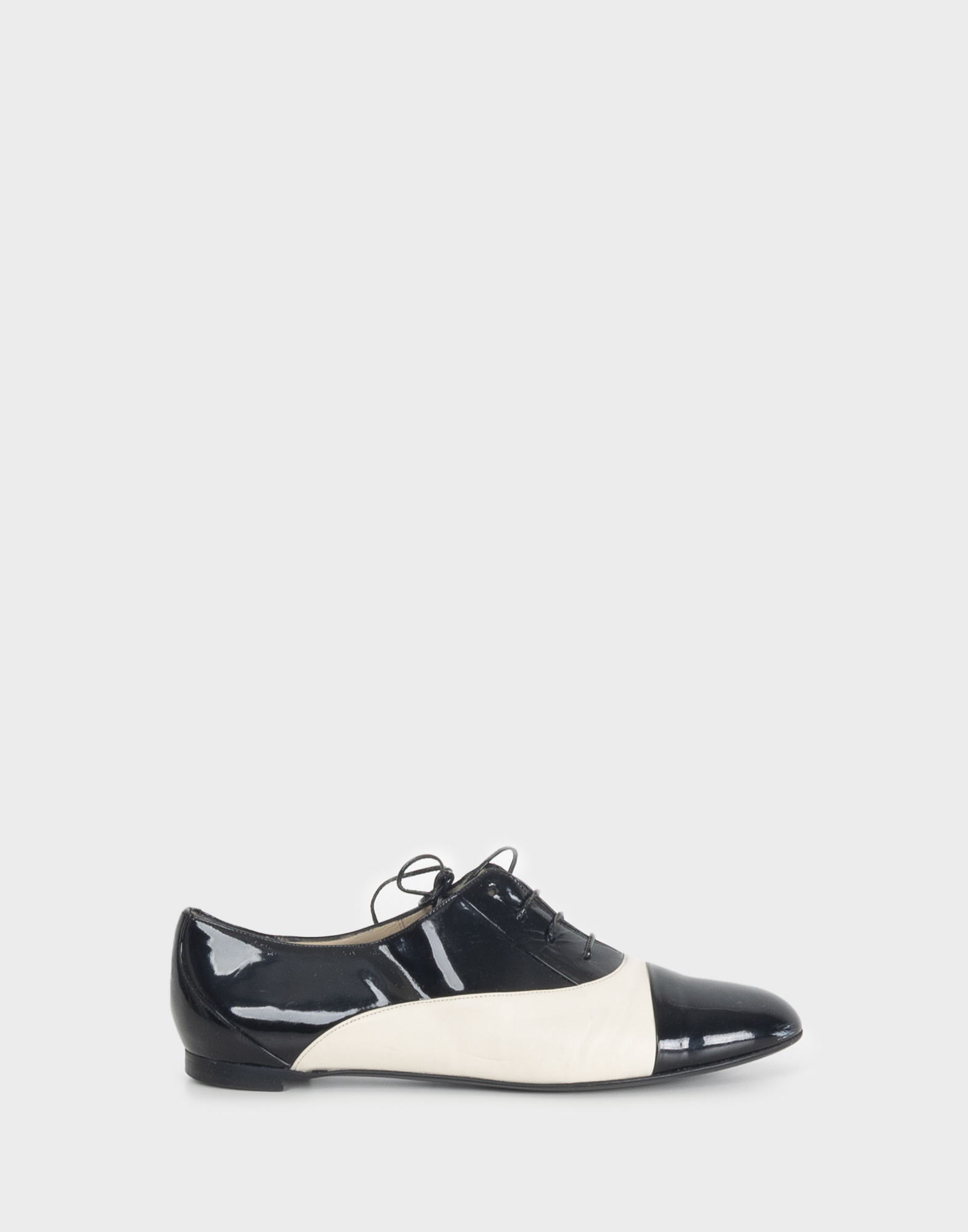 Women's black and white patent leather derby shoes with a round toe and laces.
