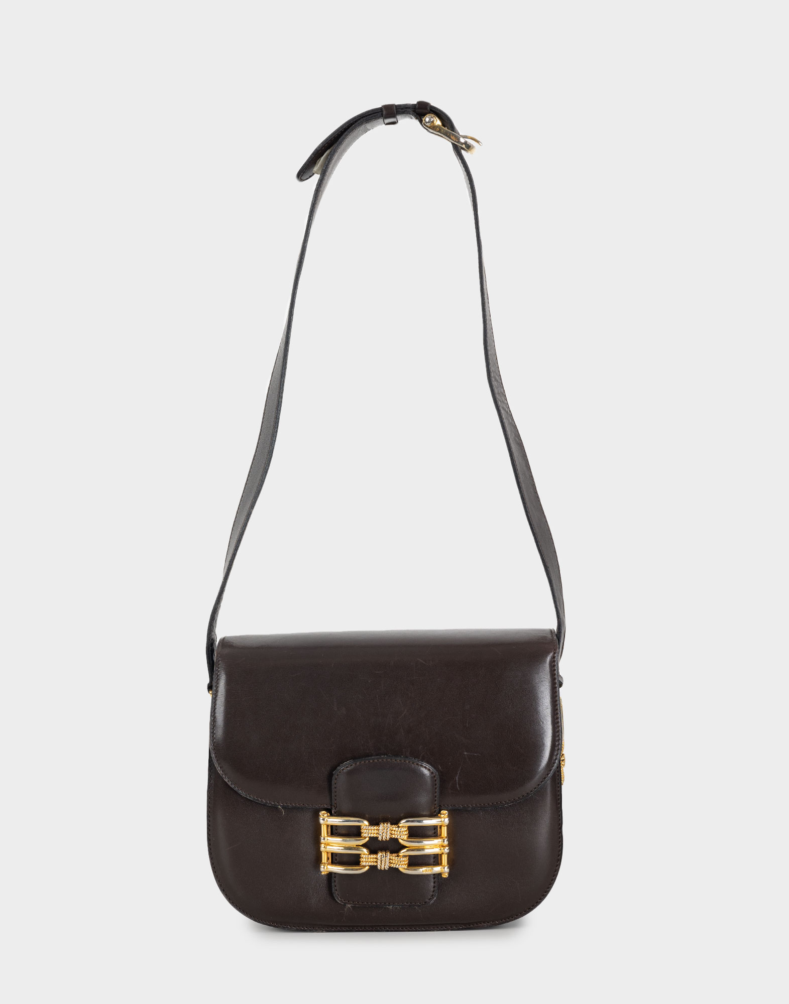 brown women's leather bag with adjustable shoulder strap, front flap closure and gold detailing