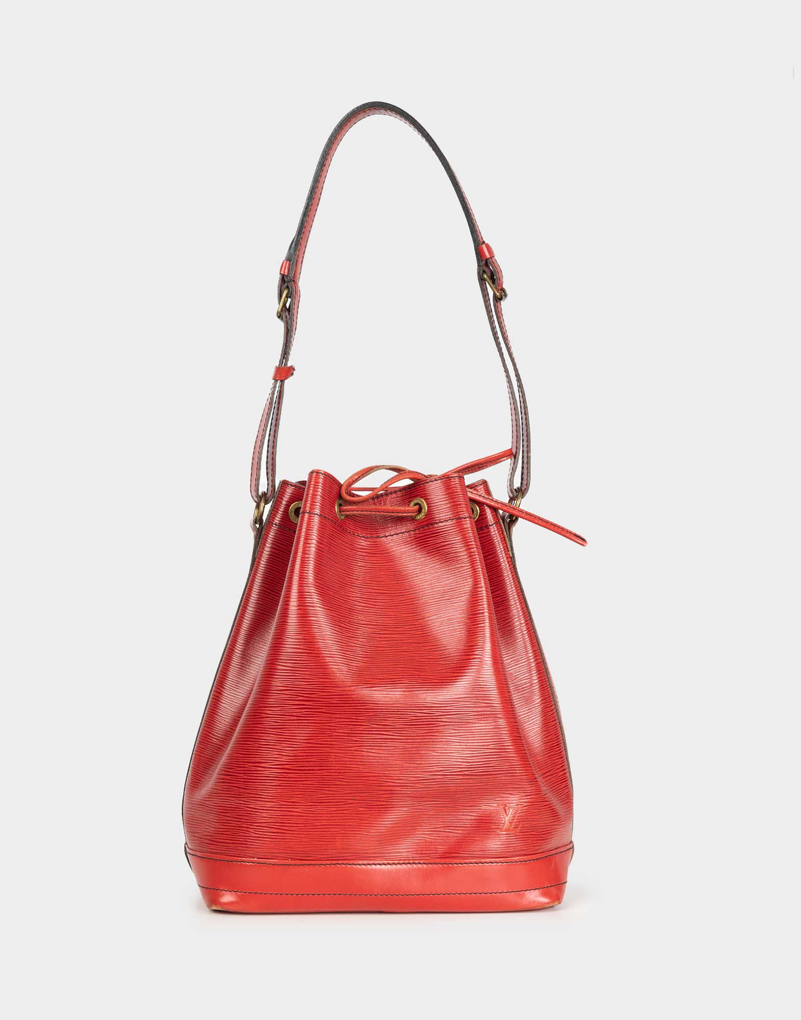 rigid red leather bucket bag with adjustable shoulder strap and drawstring closure