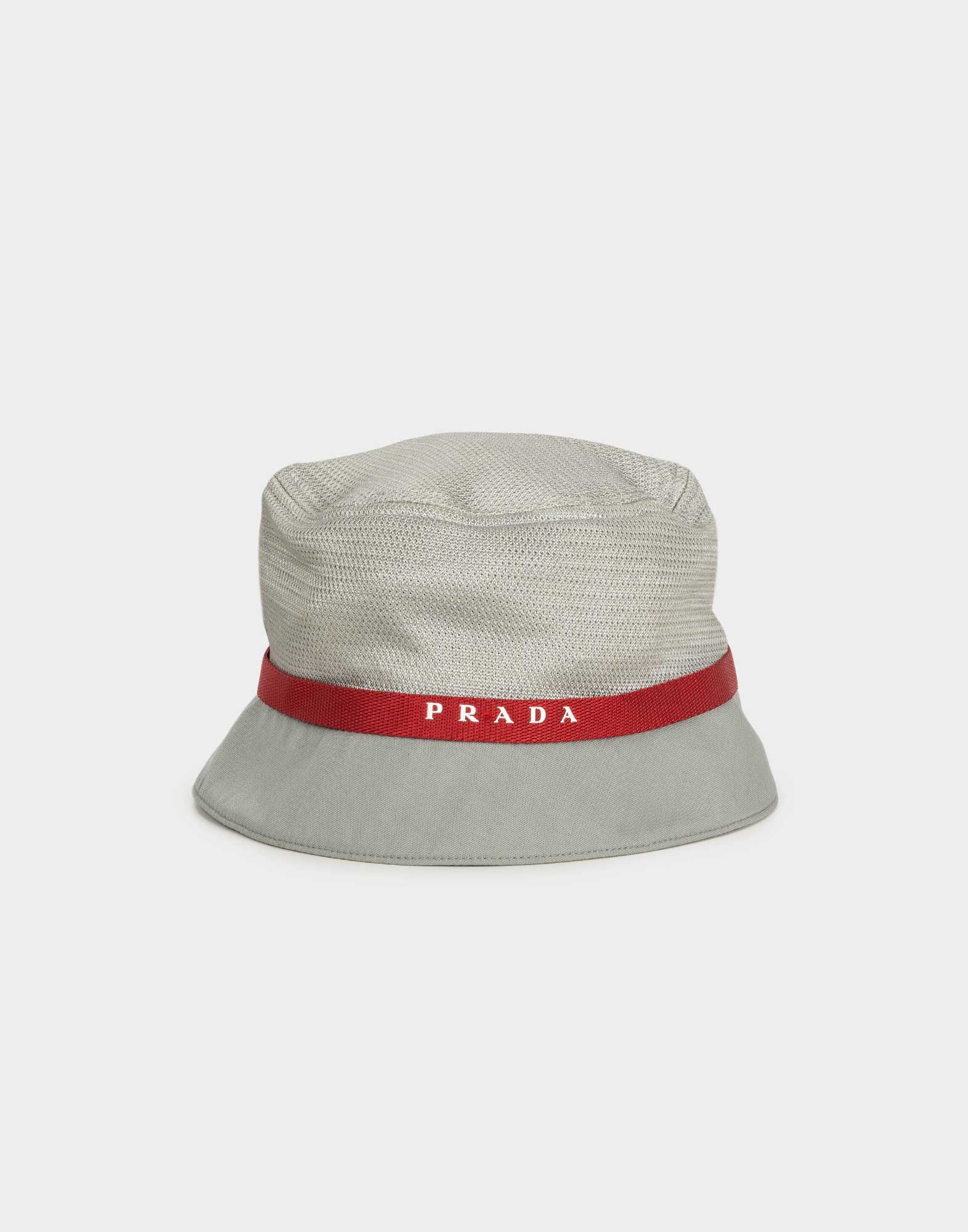 cappello grigio da uomo modello pescatore in nylon con fascia rossa riportante il logo Prada in bianco